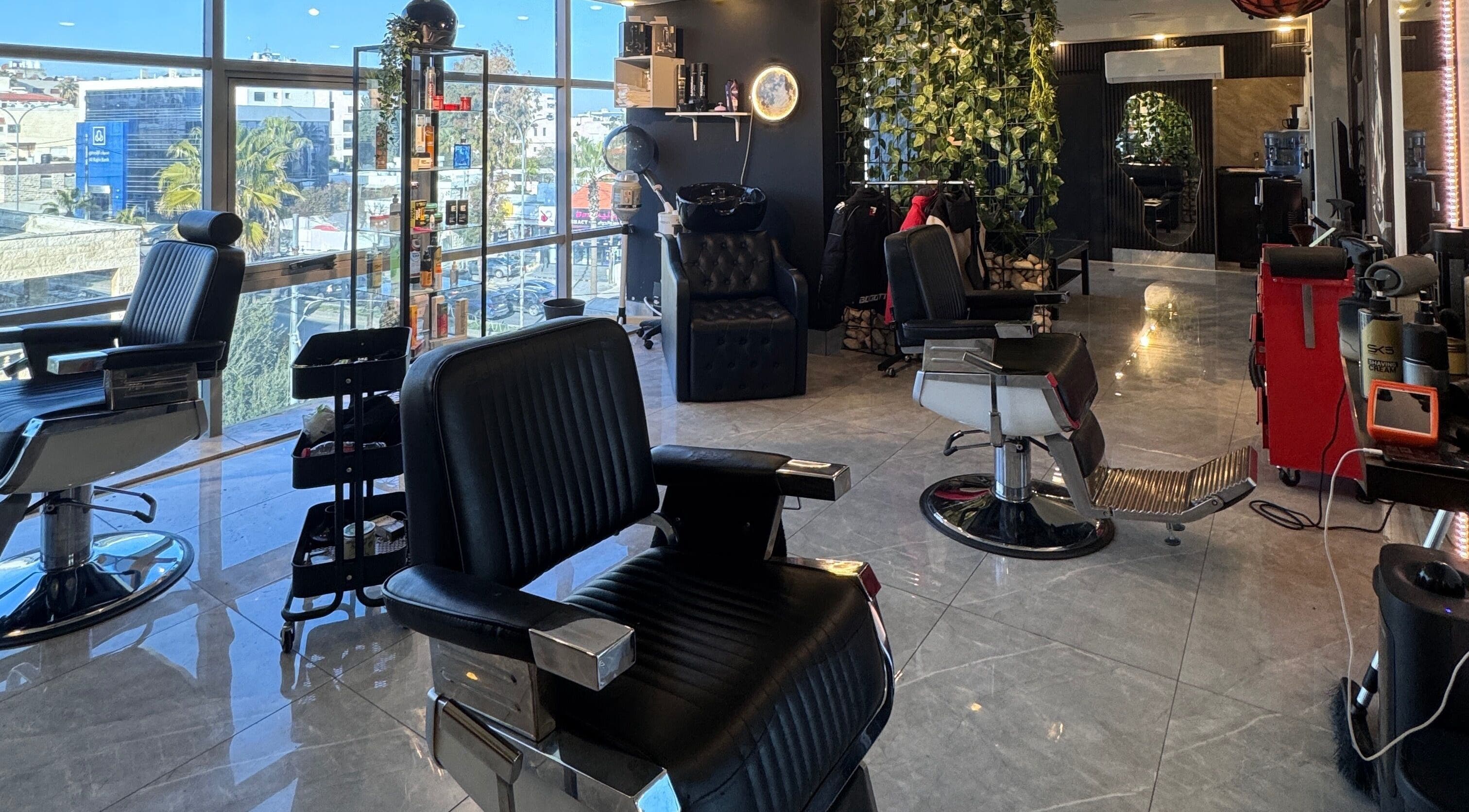 Modern barbershop at The Dala, Amman, Amman Governorate, JO, with stylish chairs and sleek decor.