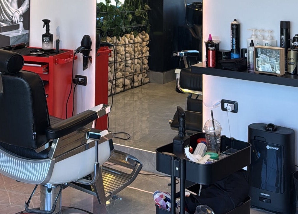 Modern salon interior at The Dala, Amman, Amman Governorate, JO featuring stylish barber chair and grooming tools.