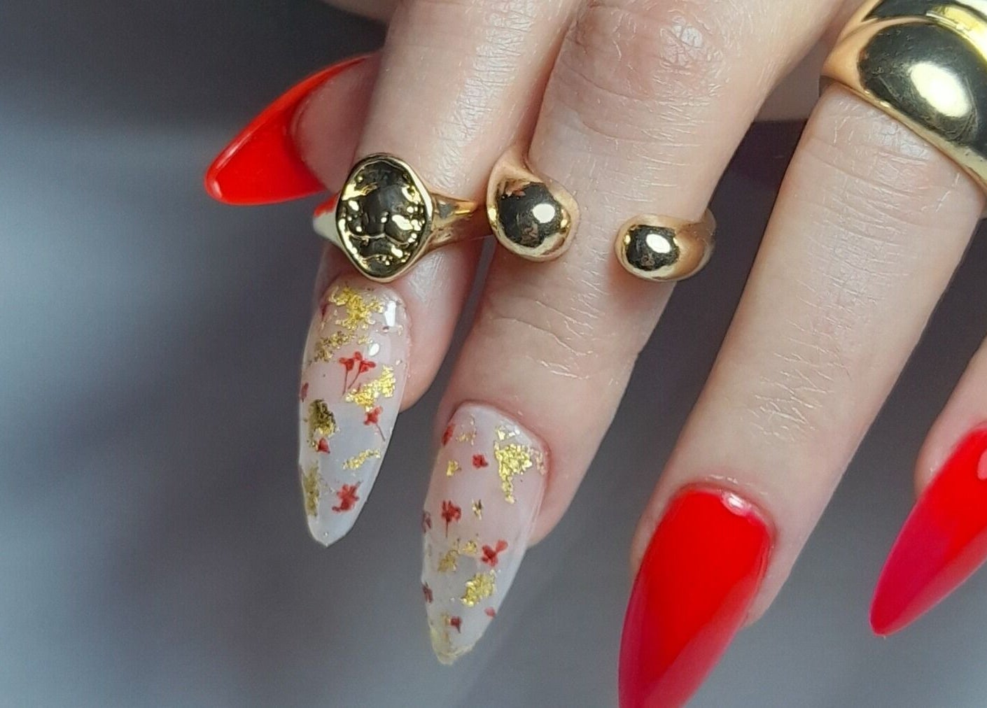 Manicura elegante en Atelier Nails Temuco, Cautin, Araucanía, CL con detalles rojos y dorados.