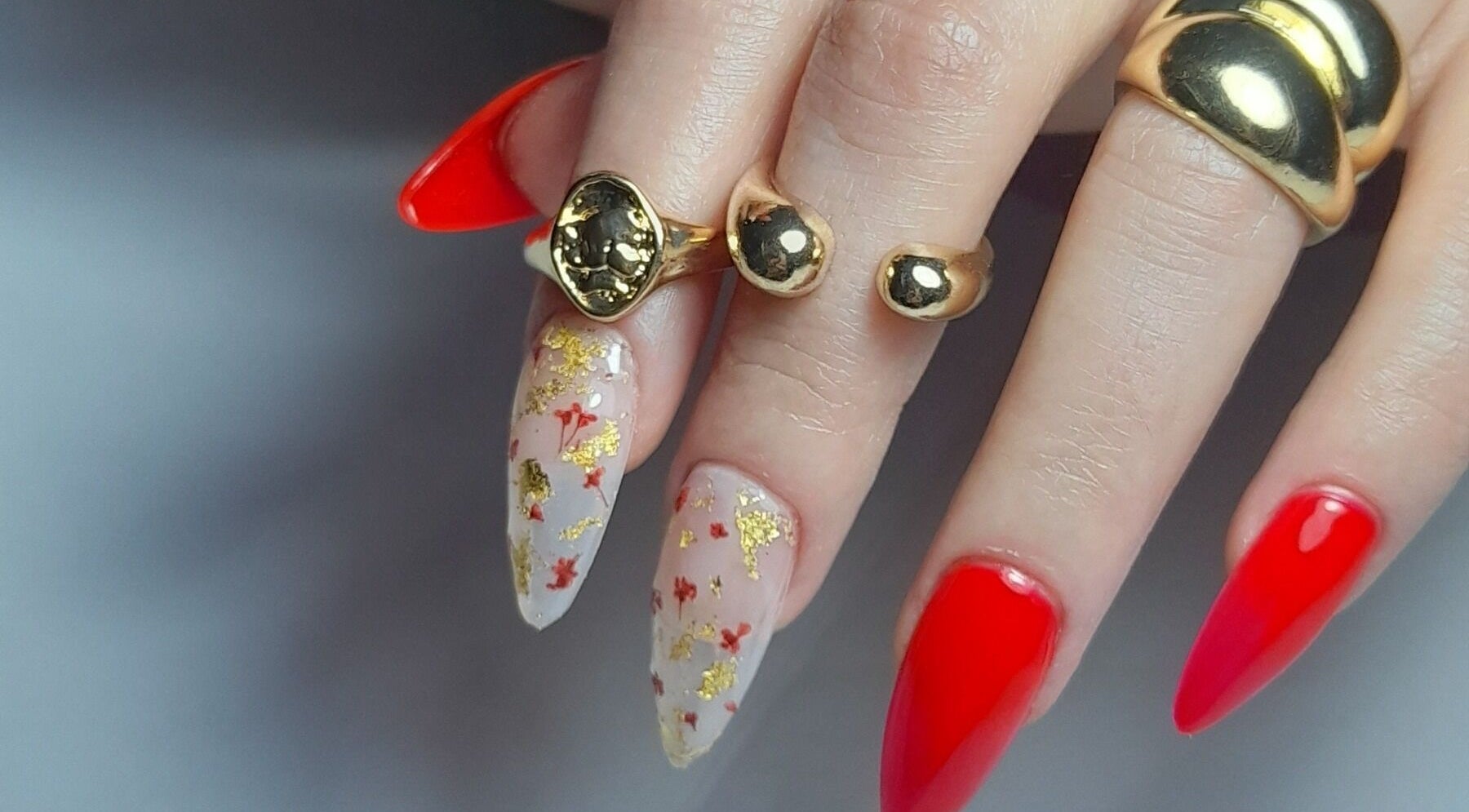 Manicura elegante en Atelier Nails Temuco, Cautin, Araucanía, CL con detalles rojos y dorados.