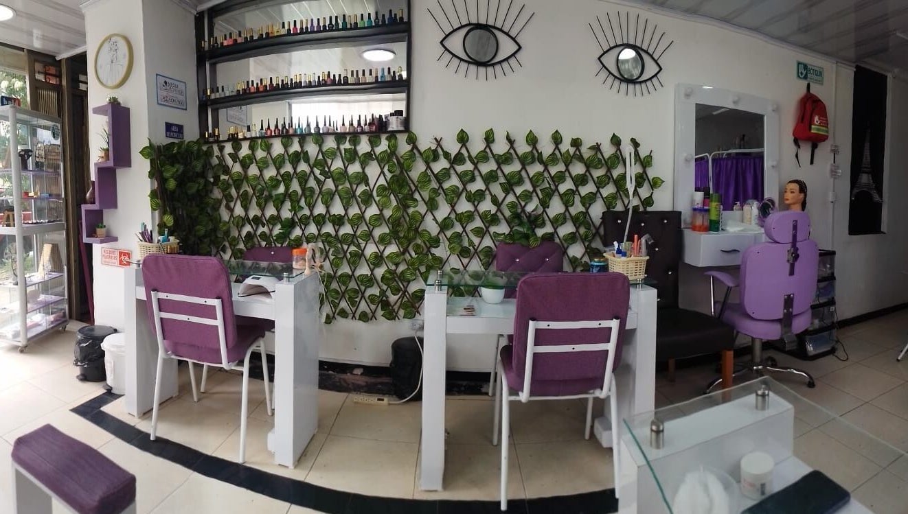 Interior de Ambar Nails y Esthetic en Bogotá, Bogotá, CO con sillas moradas y decoración de plantas.