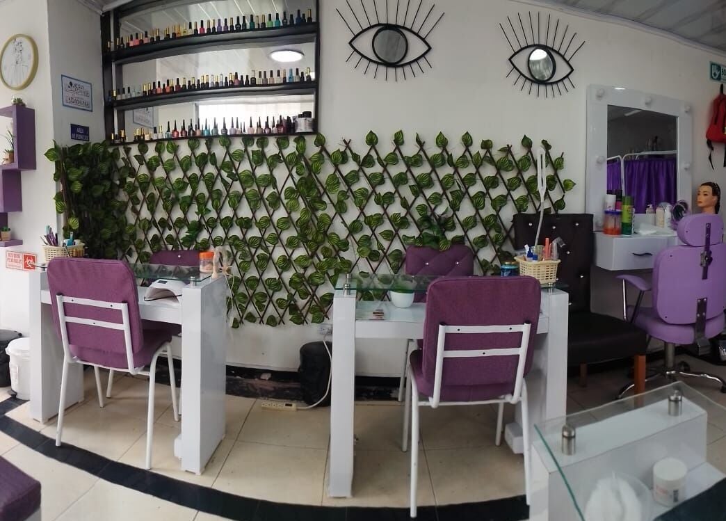 Interior de Ambar Nails y Esthetic en Bogotá, Bogotá, CO con sillas moradas y decoración de plantas.
