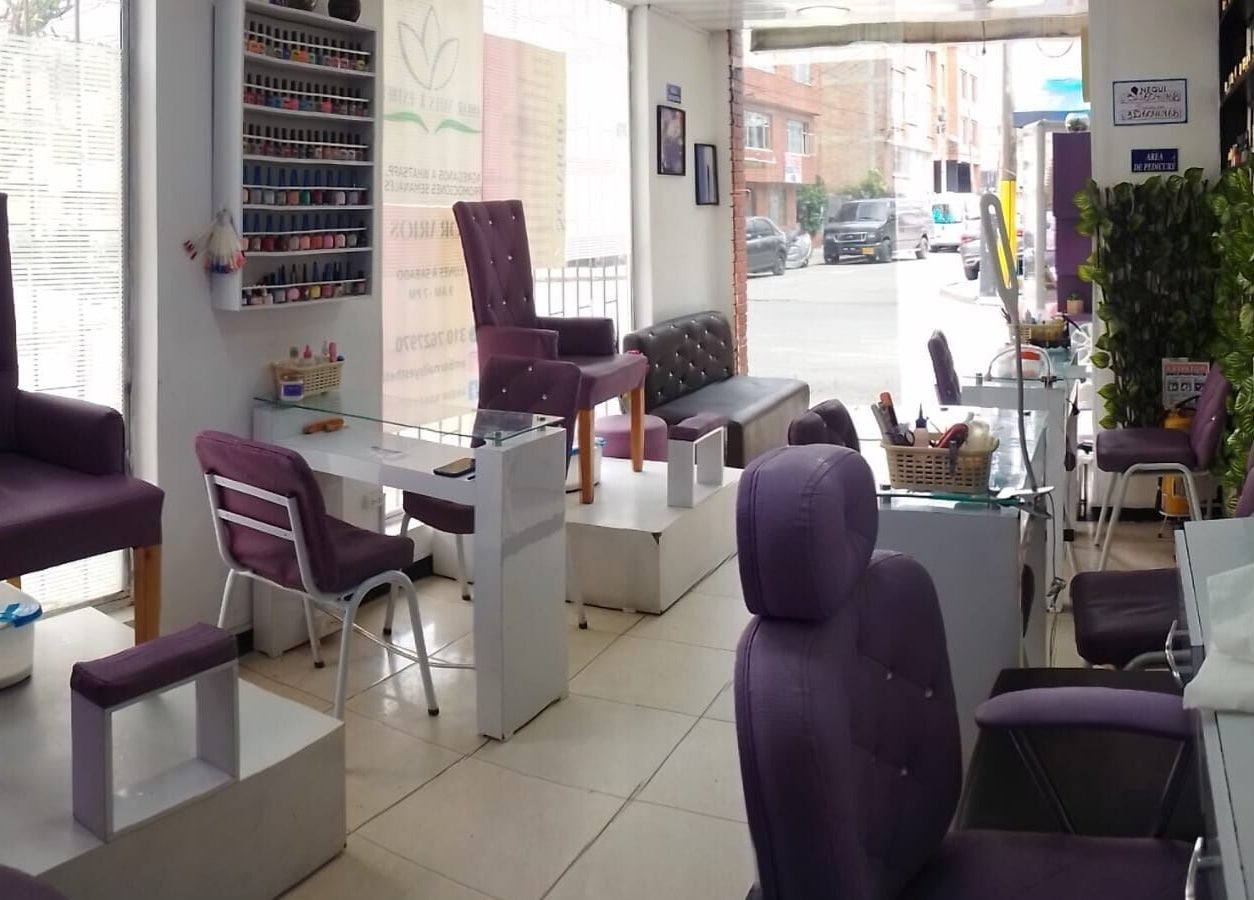 Interior de Ambar Nails y Esthetic en Bogotá, Bogotá, CO mostrando elegantes sillas de manicura y decoración.