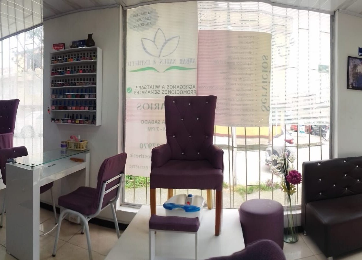 Interior de Ambar Nails y Esthetic en Bogotá, Bogotá, CO, mostrando sillas moradas y estaciones de manicura.