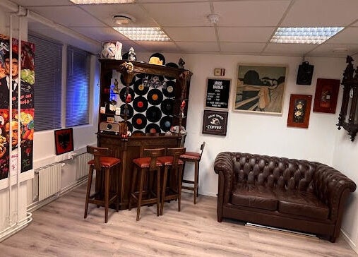Stilig barlounge på JangoBarber i Oslo, Oslo, NO, med vintage innredning og komfortable sitteplasser.