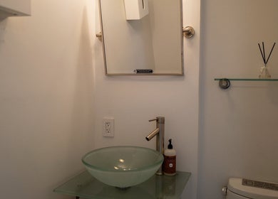 Elegant restroom vanity at Westport Lash, Westport, Connecticut, US, featuring glass sink and modern mirror.