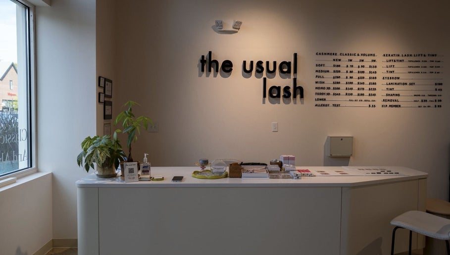 Reception desk at The Usual Lash, Darien, Connecticut, US, showcasing a modern design and service menu.