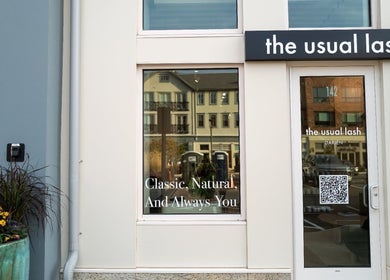 Entrance of The Usual Lash, Darien, Connecticut, US with stylish signage and a flower pot.