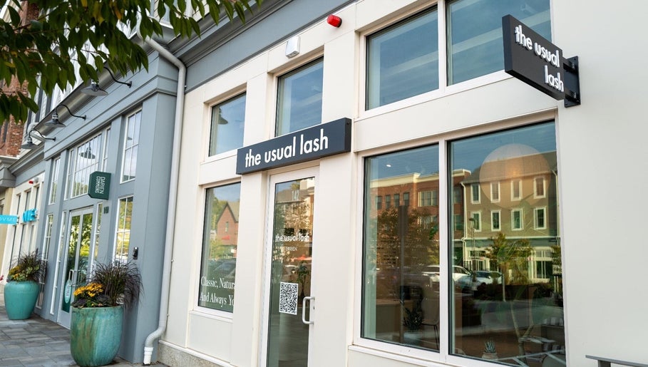 Exterior view of The Usual Lash in Darien, Connecticut, US, featuring elegant signage and large windows.