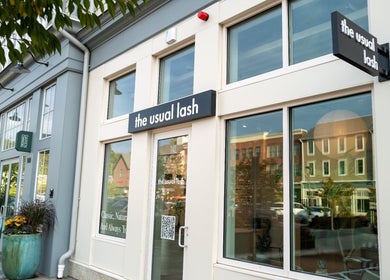 Exterior view of The Usual Lash in Darien, Connecticut, US, featuring elegant signage and large windows.