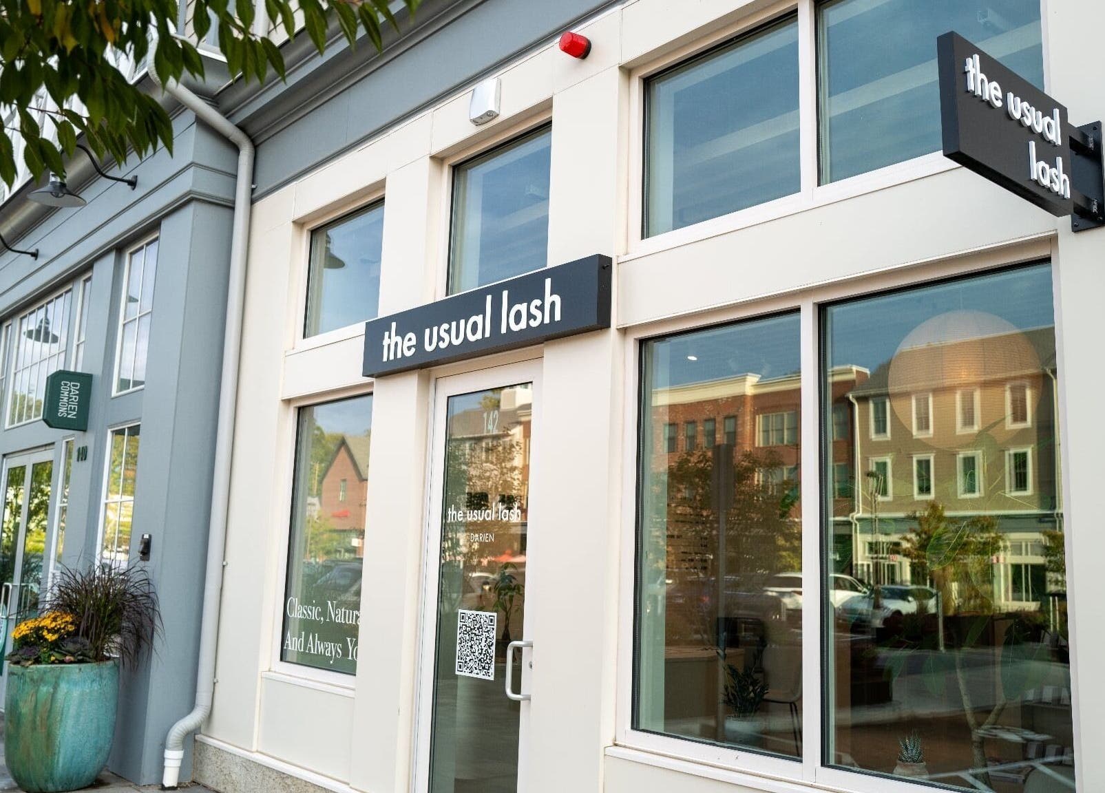 Exterior view of The Usual Lash in Darien, Connecticut, US, featuring elegant signage and large windows.