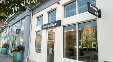 Exterior view of The Usual Lash in Darien, Connecticut, US, featuring elegant signage and large windows.