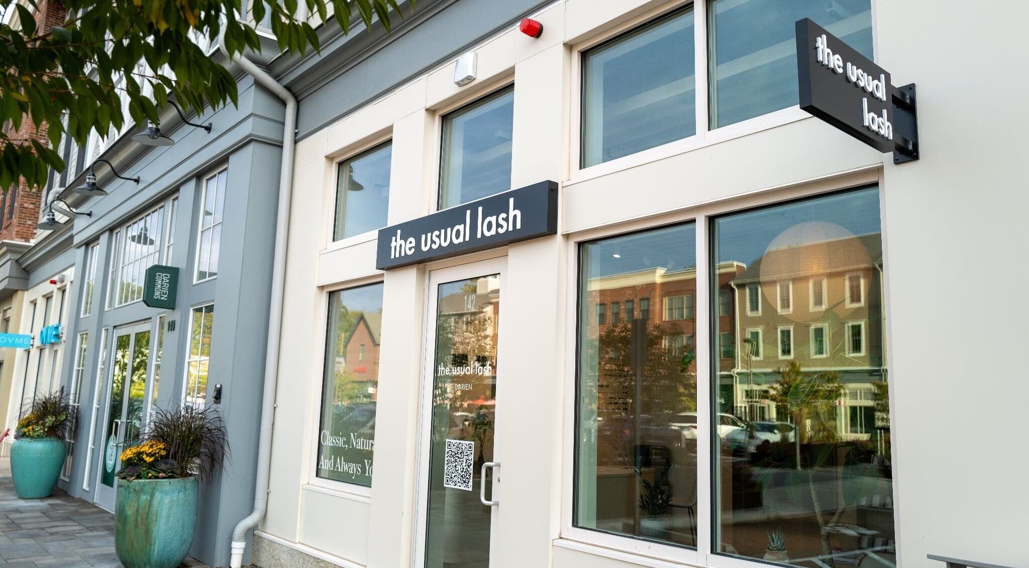 Exterior view of The Usual Lash in Darien, Connecticut, US, featuring elegant signage and large windows.