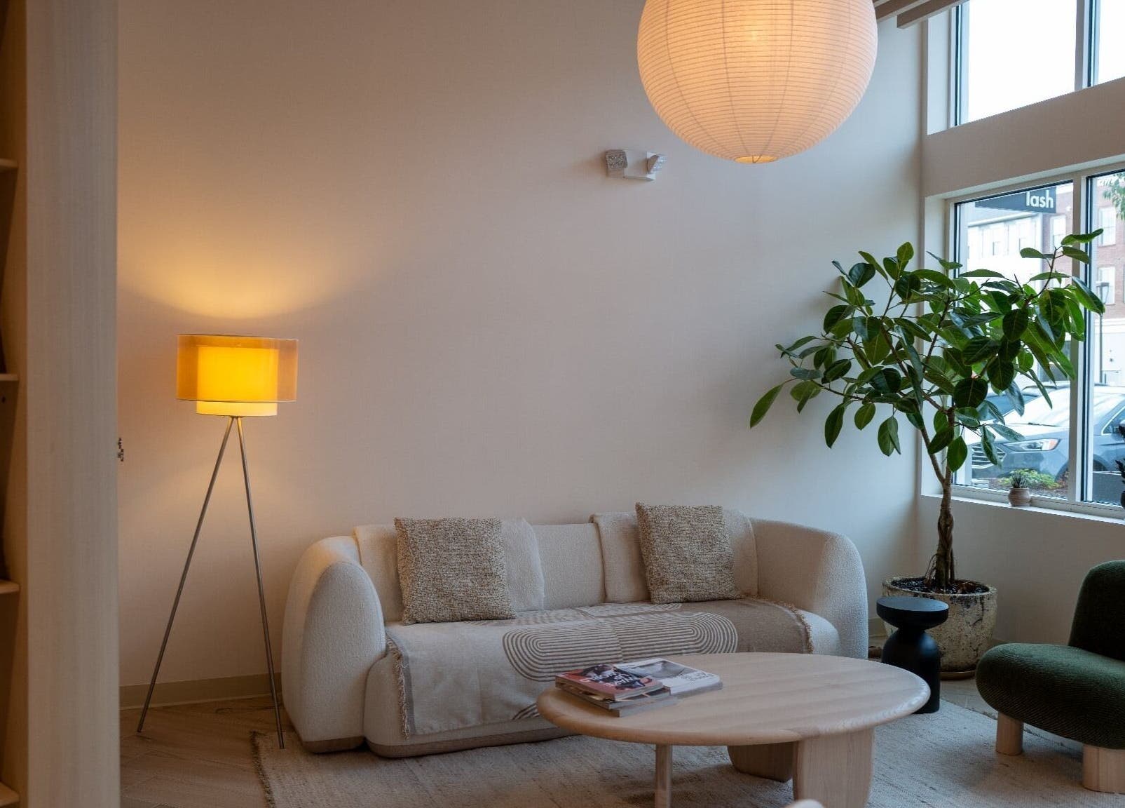 Bright lounge at The Usual Lash, Darien, Connecticut, US, featuring a modern sofa and large window.