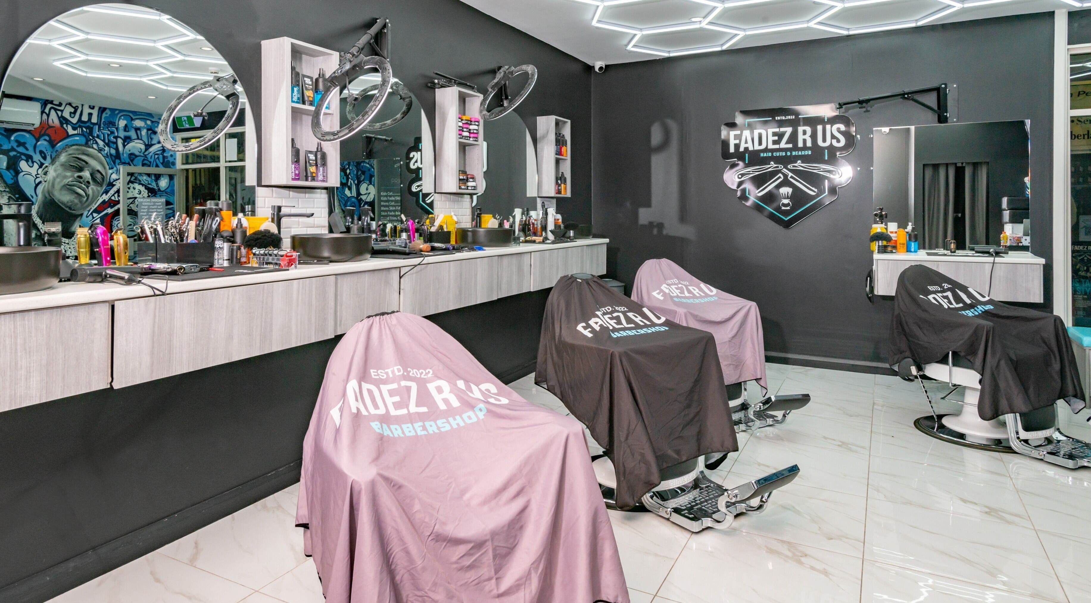 Modern interior of FADEZ R US, Penrith NSW with styling chairs and tools, showcasing a trendy barbershop setup.