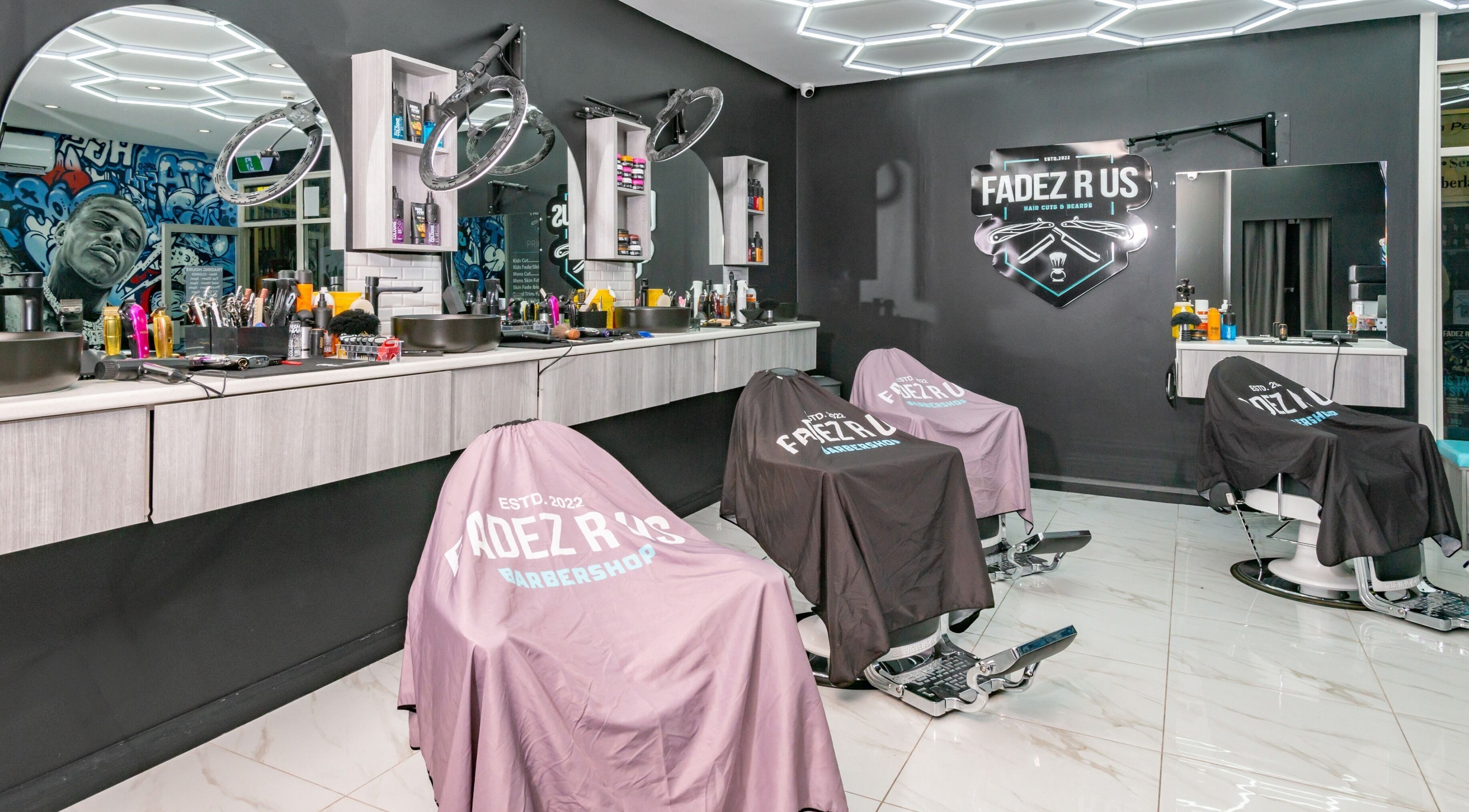 Modern interior of FADEZ R US, Penrith NSW with styling chairs and tools, showcasing a trendy barbershop setup.