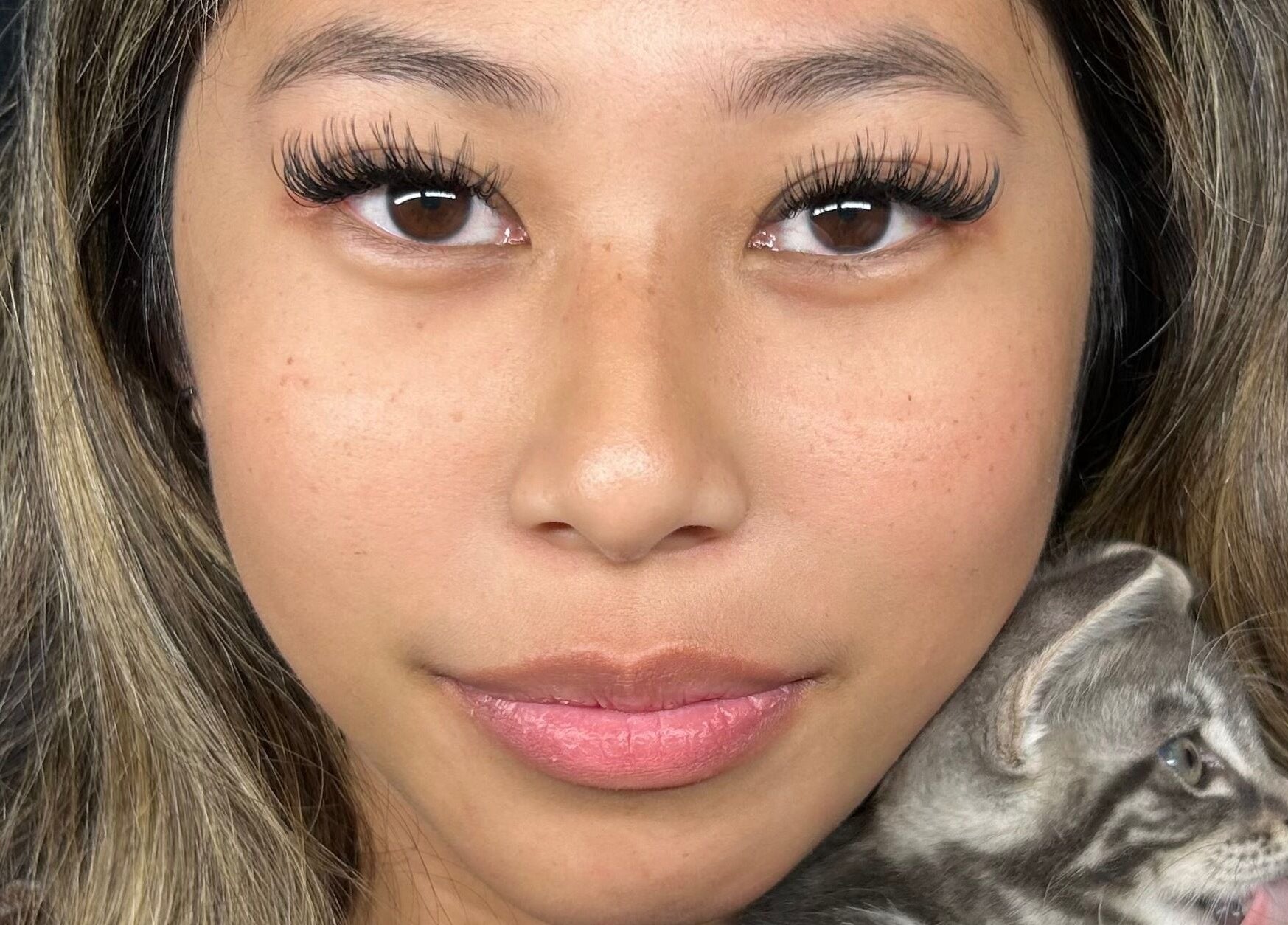 Close-up of woman with stunning lashes and kitten at CeLuxe Aesthetics, Southport, Queensland, AU.