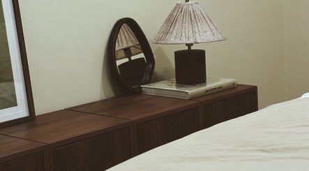 Elegant bedside decor at Emma W Beauty at Muse Studio, Bristol, England, GB featuring a lamp and mirror.
