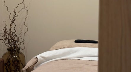 Cozy massage bed at Emma W Beauty at Muse Studio, Bristol, England, GB. Warm lighting and decor enhance the ambiance.