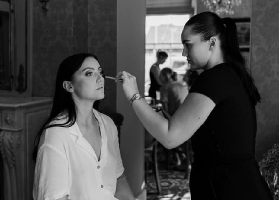 Makeup artist at Emma W Beauty in Bristol, England, GB, applying eyeshadow to a client.