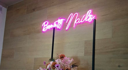 Neonbord 'Beauty Nails' omringd door bloemen bij Beauty Nails & Beauty Feets, Ede, Gelderland, NL.