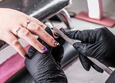 Nail technician filing vibrant nails at Yolanush Beauty Lounge, Kempton Park, Gauteng, ZA.