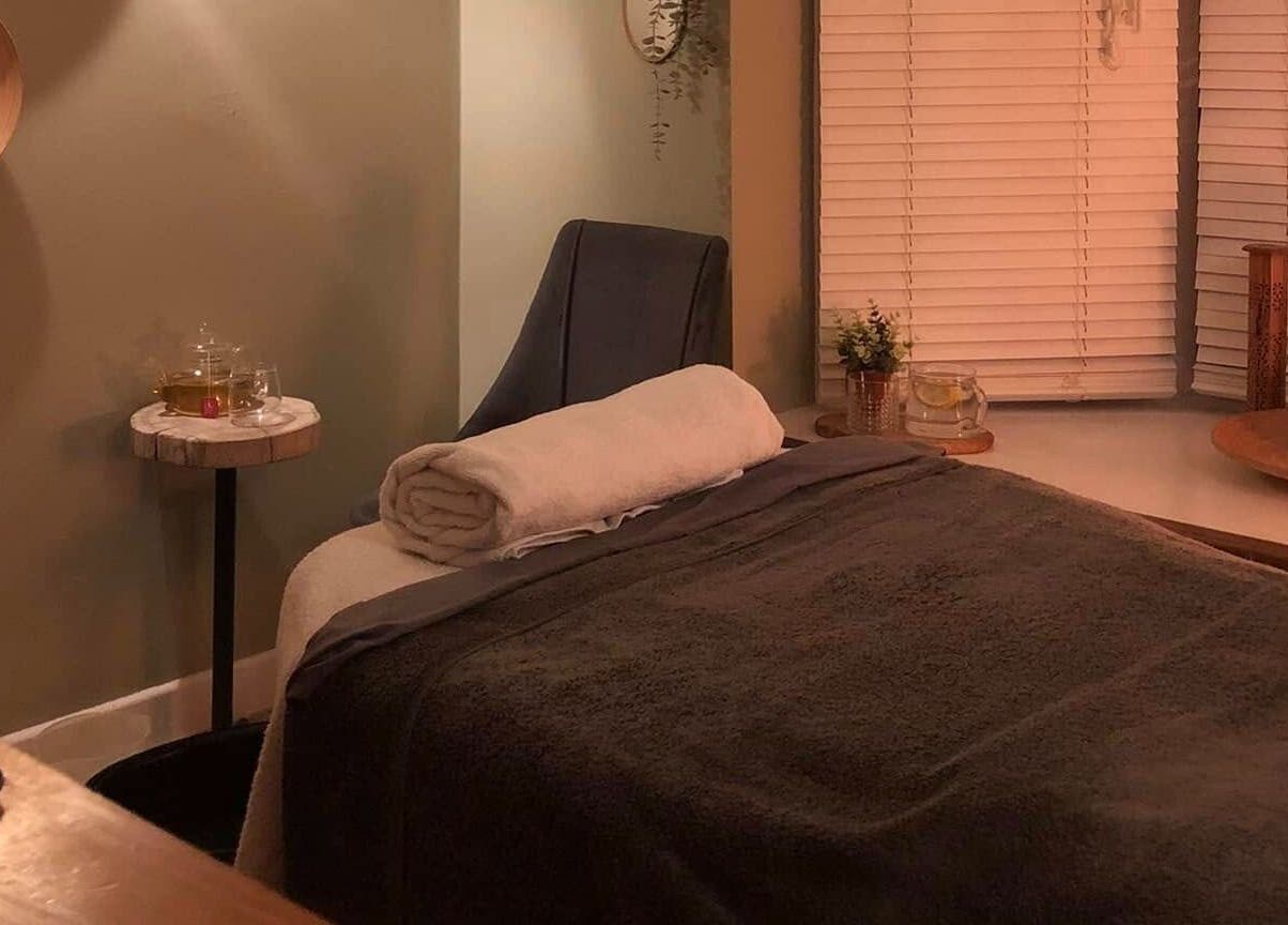Cozy massage room at Apple Lodge Therapies, Redditch, England, GB, with a massage bed, candlelight, and tranquil decor.