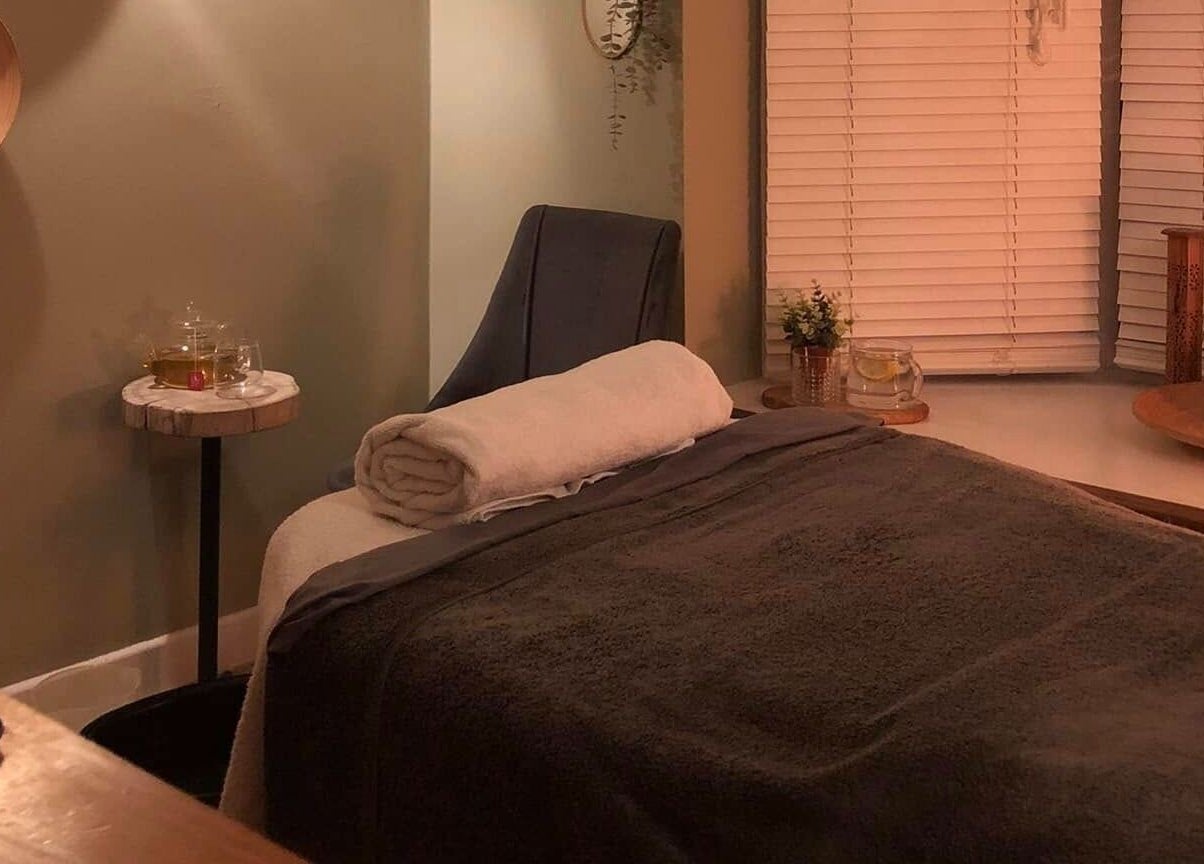 Cozy massage room at Apple Lodge Therapies, Redditch, England, GB, with a massage bed, candlelight, and tranquil decor.