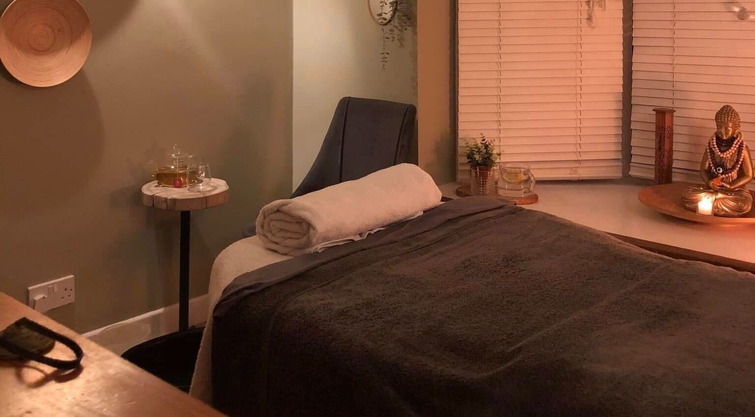 Cozy massage room at Apple Lodge Therapies, Redditch, England, GB, with a massage bed, candlelight, and tranquil decor.