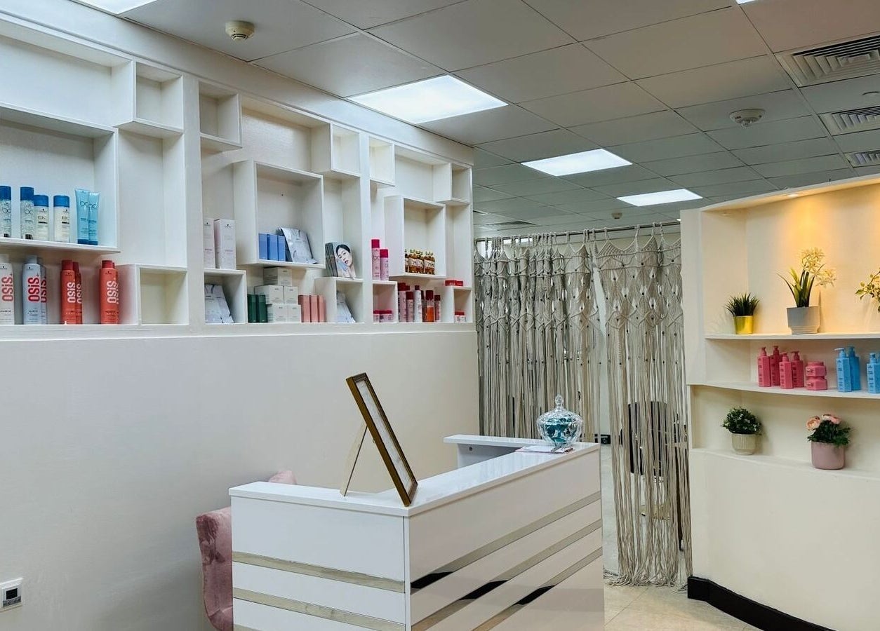 Reception area of Korea Beauty Salon in Muscat, featuring sleek shelves with beauty products and elegant decor.