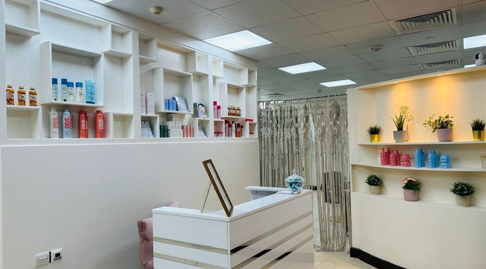 Reception area of Korea Beauty Salon in Muscat, featuring sleek shelves with beauty products and elegant decor.