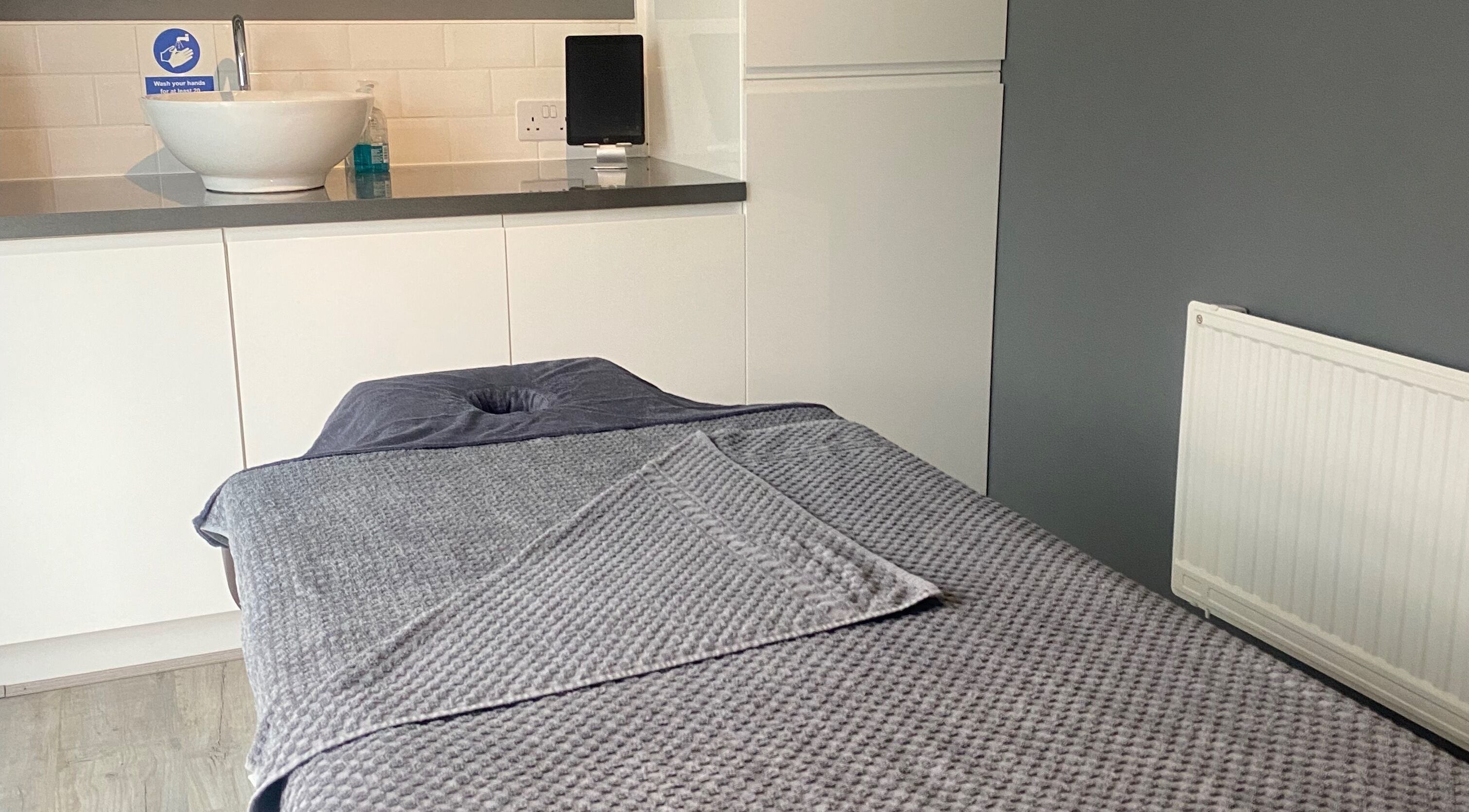 Massage table in The Garden Retreat, Well, England, GB with cozy setup and soft lighting.