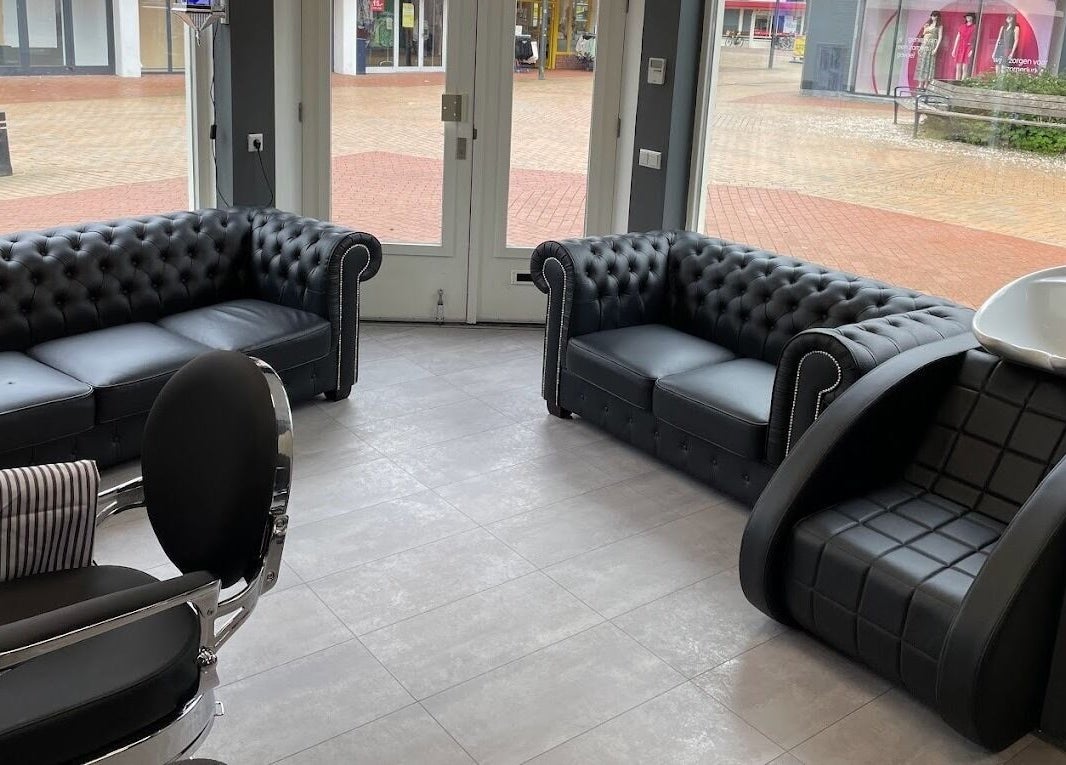 Comfortabele zithoek bij Ilyana Kapsalon, Drachten, Friesland, NL. Moderne inrichting en stijlvolle fauteuils.