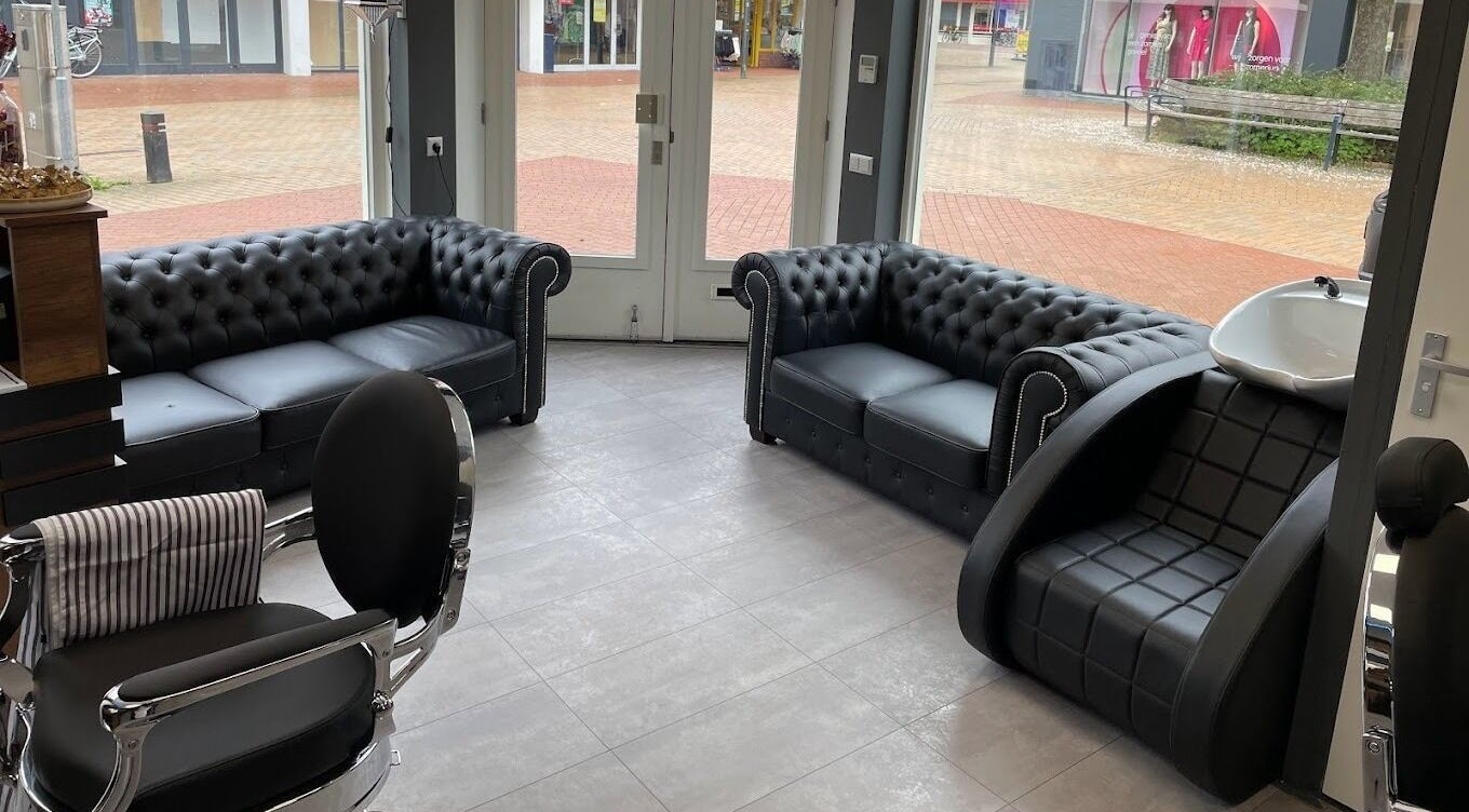 Comfortabele zithoek bij Ilyana Kapsalon, Drachten, Friesland, NL. Moderne inrichting en stijlvolle fauteuils.