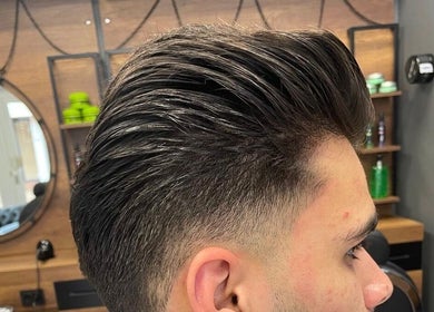 Trendy herenkapsel bij Ilyana Kapsalon, Drachten, Friesland, NL. Modern interieur op de achtergrond.