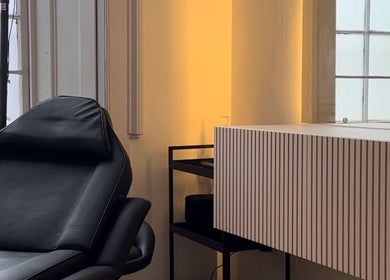 Cozy treatment room at Justdemi., House of Naf! in Glasgow, Scotland, GB with a plush black chair.