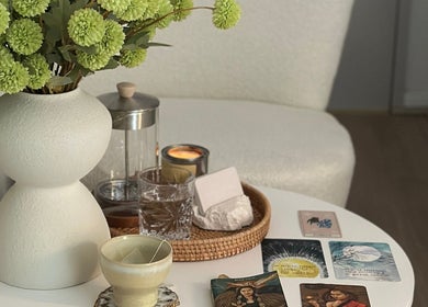 A serene spa setup at The Skin & Soul Spa, Eastgardens, New South Wales, AU with a vase of flowers, candles, and cards.