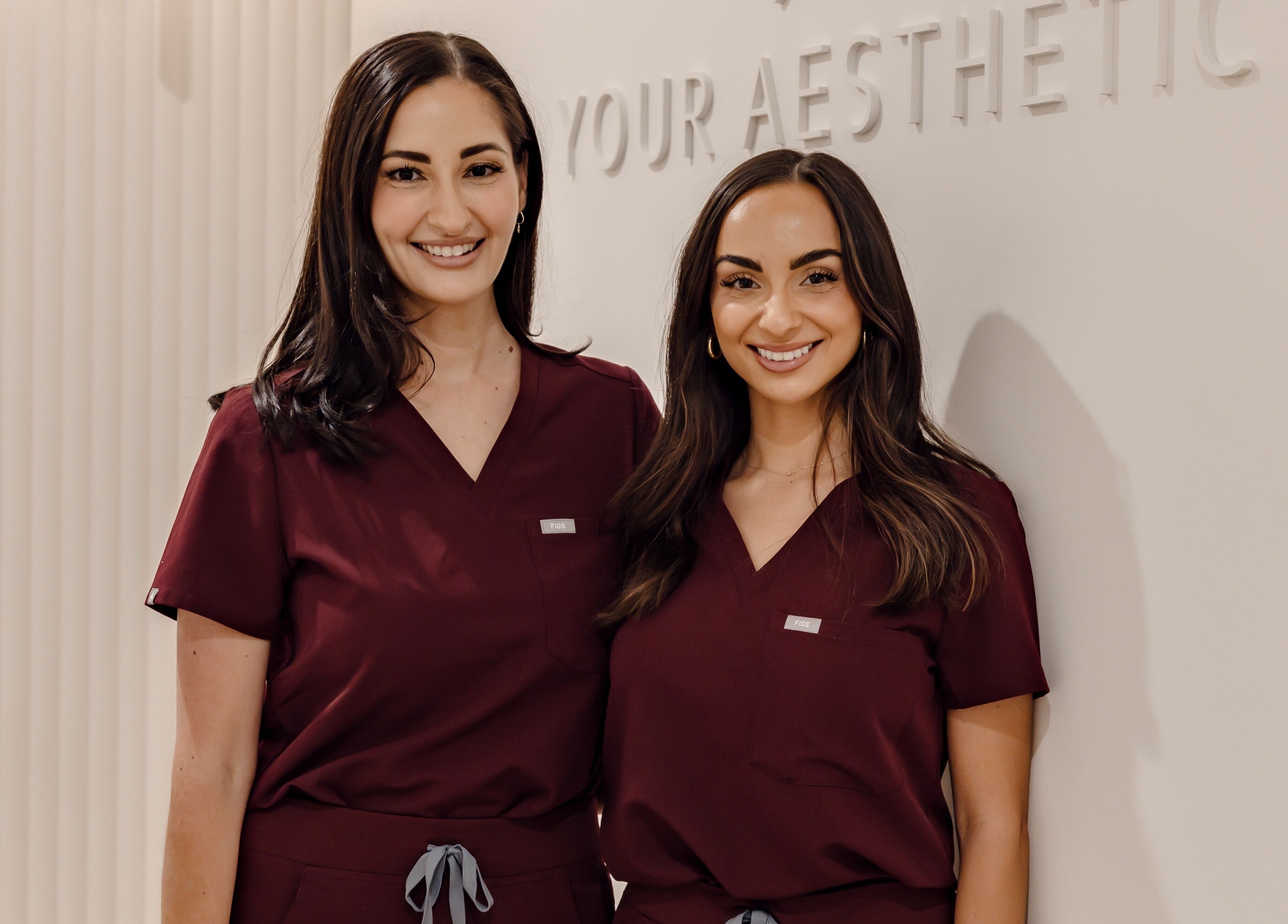 Professional staff at Your Aesthetic in Berwick, VIC, AU smiling in front of logo.