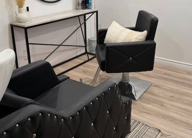 Elegant salon interior at Hairstyling by Taitum in Renfrew, Ontario, CA with modern black chairs.