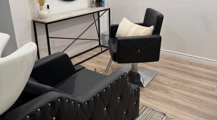 Elegant salon interior at Hairstyling by Taitum in Renfrew, Ontario, CA with modern black chairs.