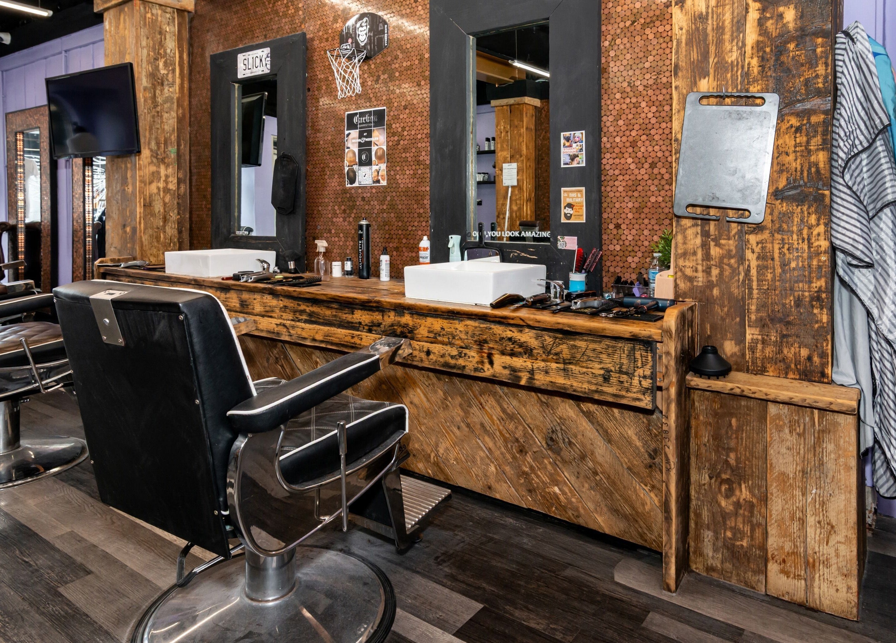 Interior of Skins & Needles Barbers in Middlesbrough, England, GB, showcasing stylish barber chairs and rustic decor.