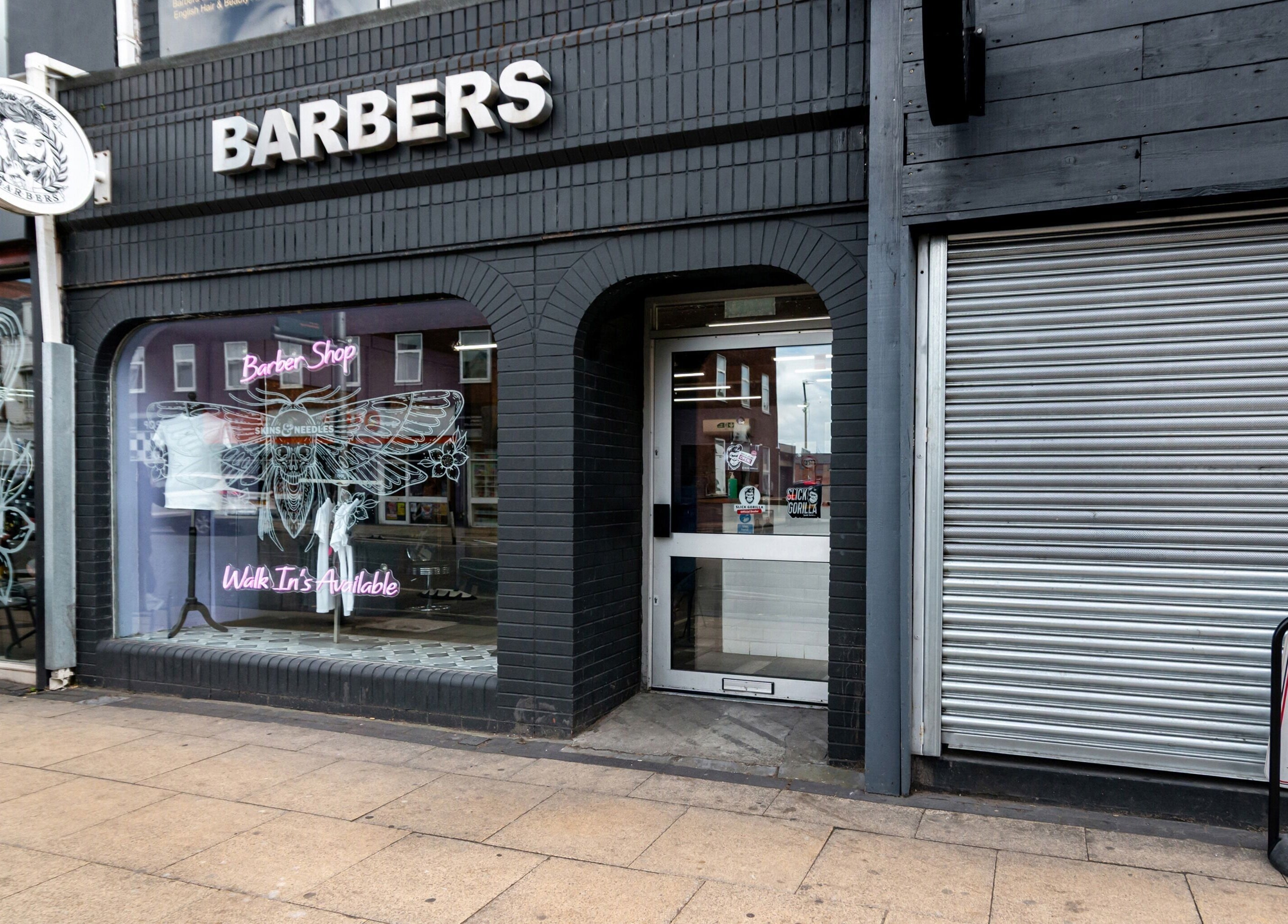 Front view of Skins & Needles Barbers shop in Middlesbrough, England with its distinctive signage and entryway.