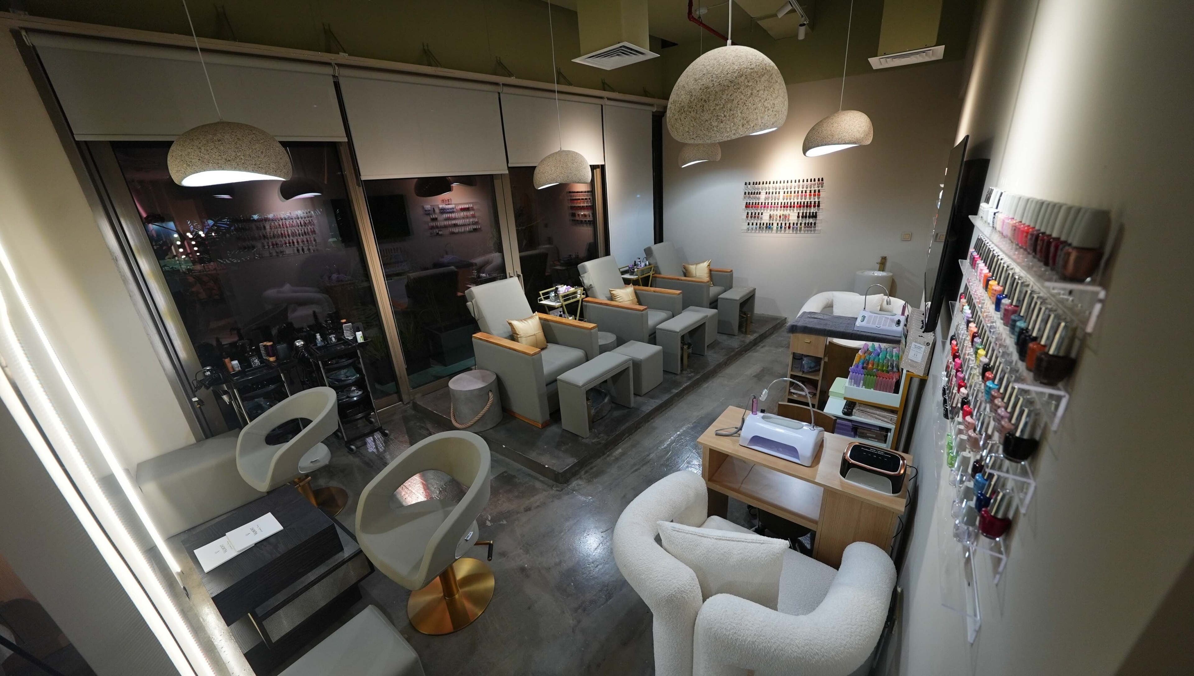Chic interior of Aceituna Beauty Salon L.L.C in Dubai, Dubai, AE with modern seating and nail polish display.