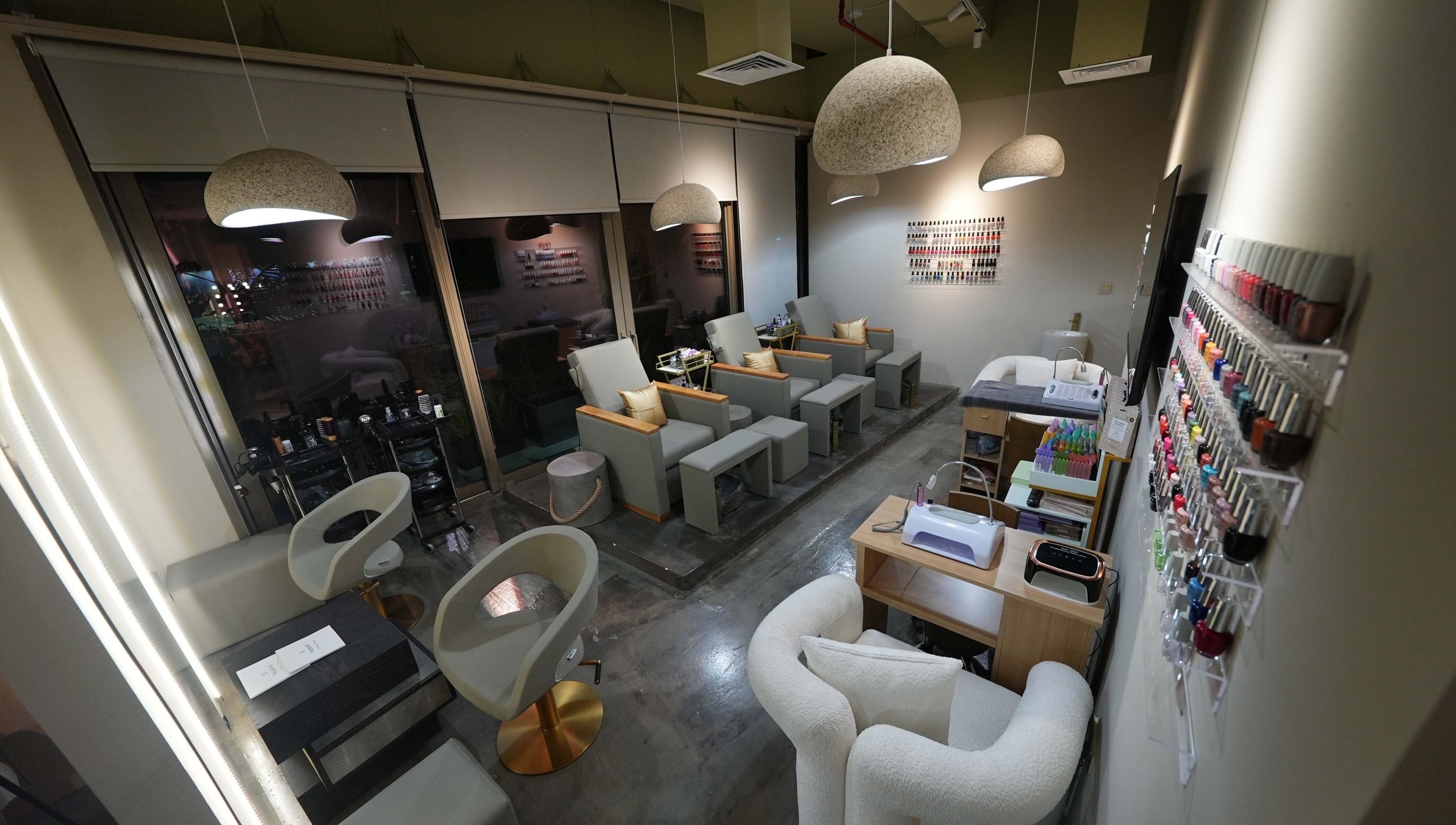 Chic interior of Aceituna Beauty Salon L.L.C in Dubai, Dubai, AE with modern seating and nail polish display.