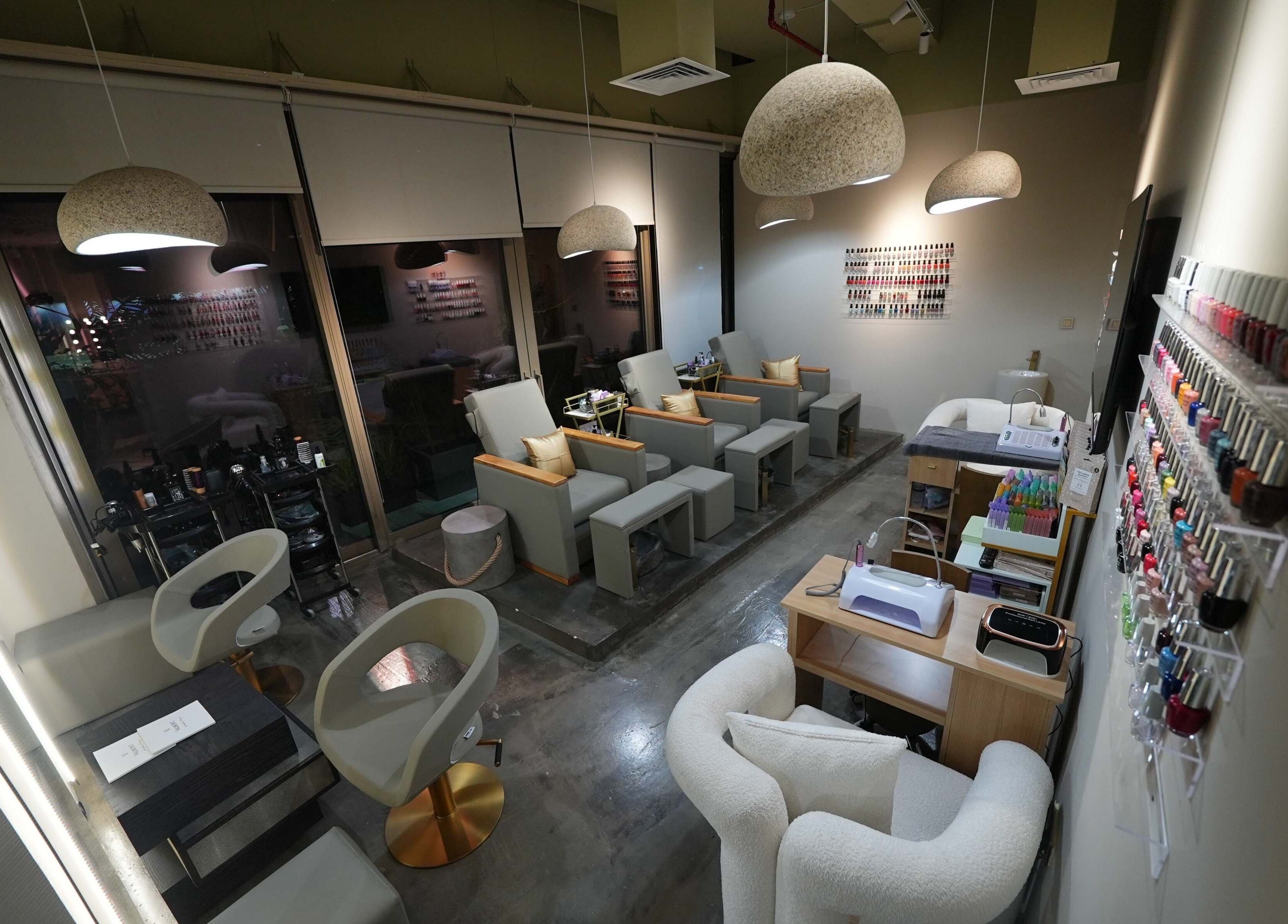 Chic interior of Aceituna Beauty Salon L.L.C in Dubai, Dubai, AE with modern seating and nail polish display.
