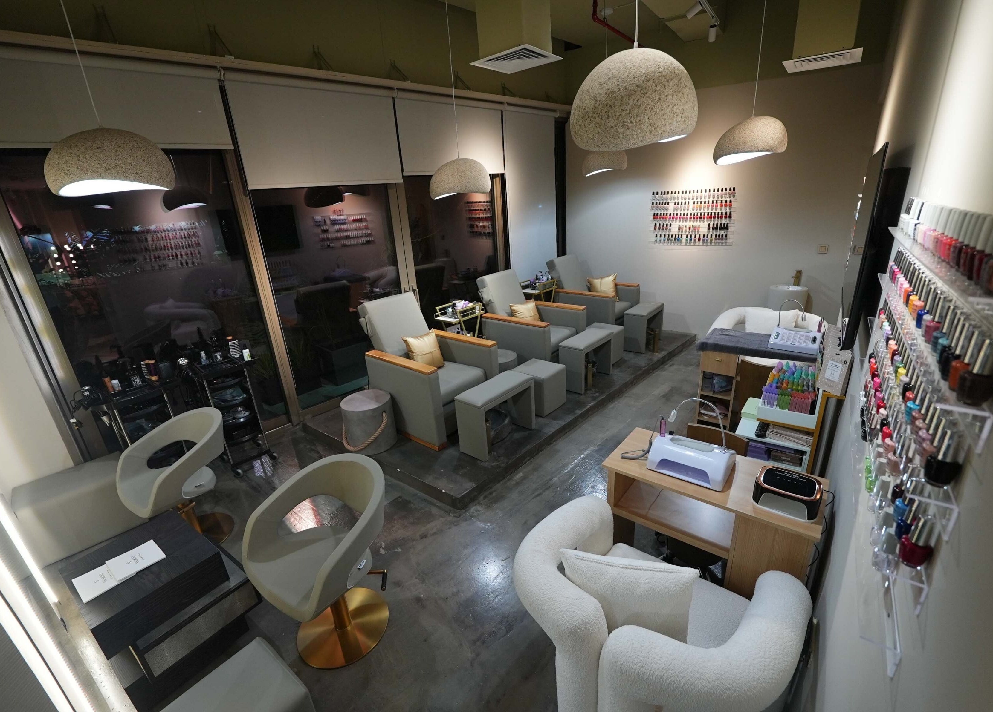 Chic interior of Aceituna Beauty Salon L.L.C in Dubai, Dubai, AE with modern seating and nail polish display.