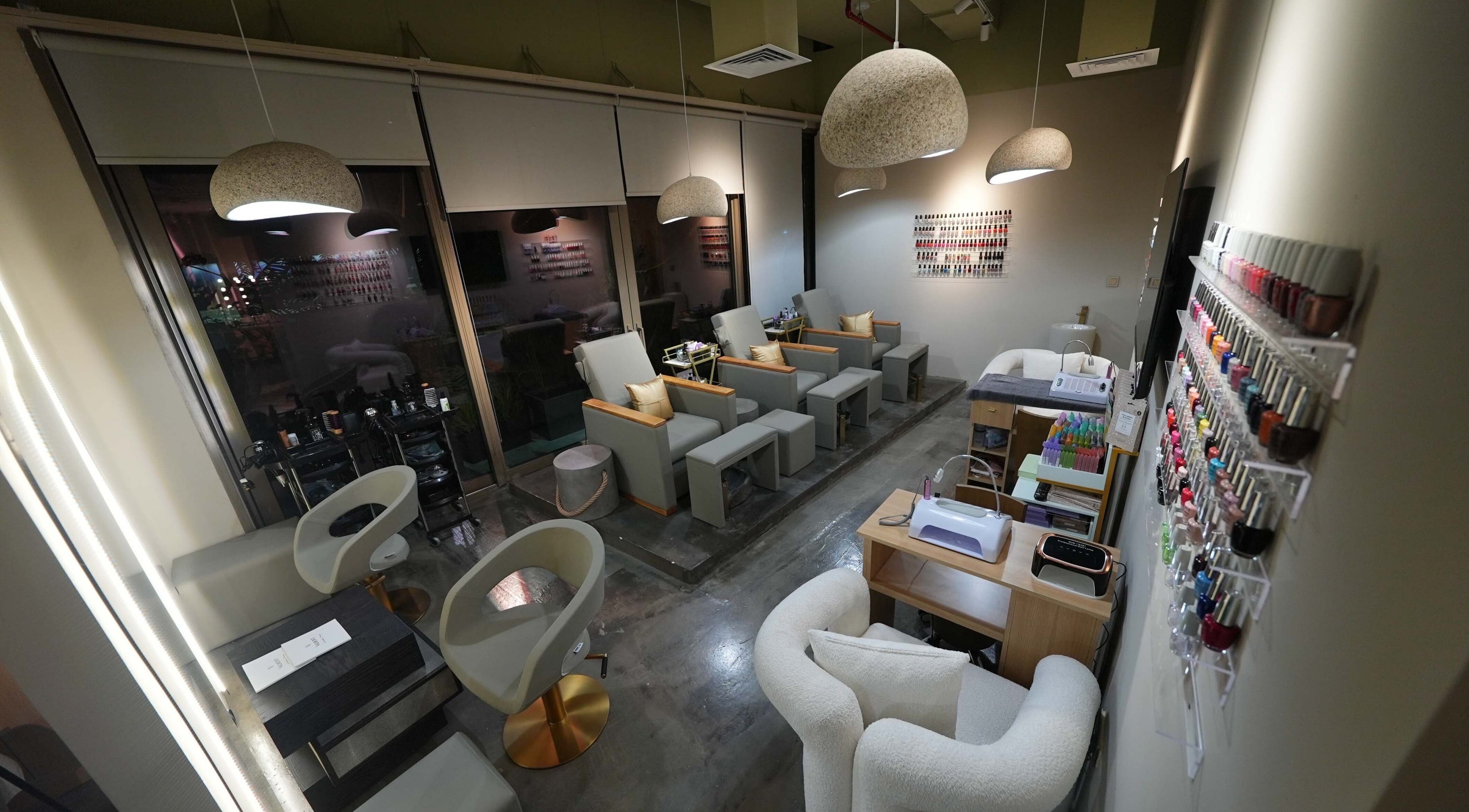 Chic interior of Aceituna Beauty Salon L.L.C in Dubai, Dubai, AE with modern seating and nail polish display.