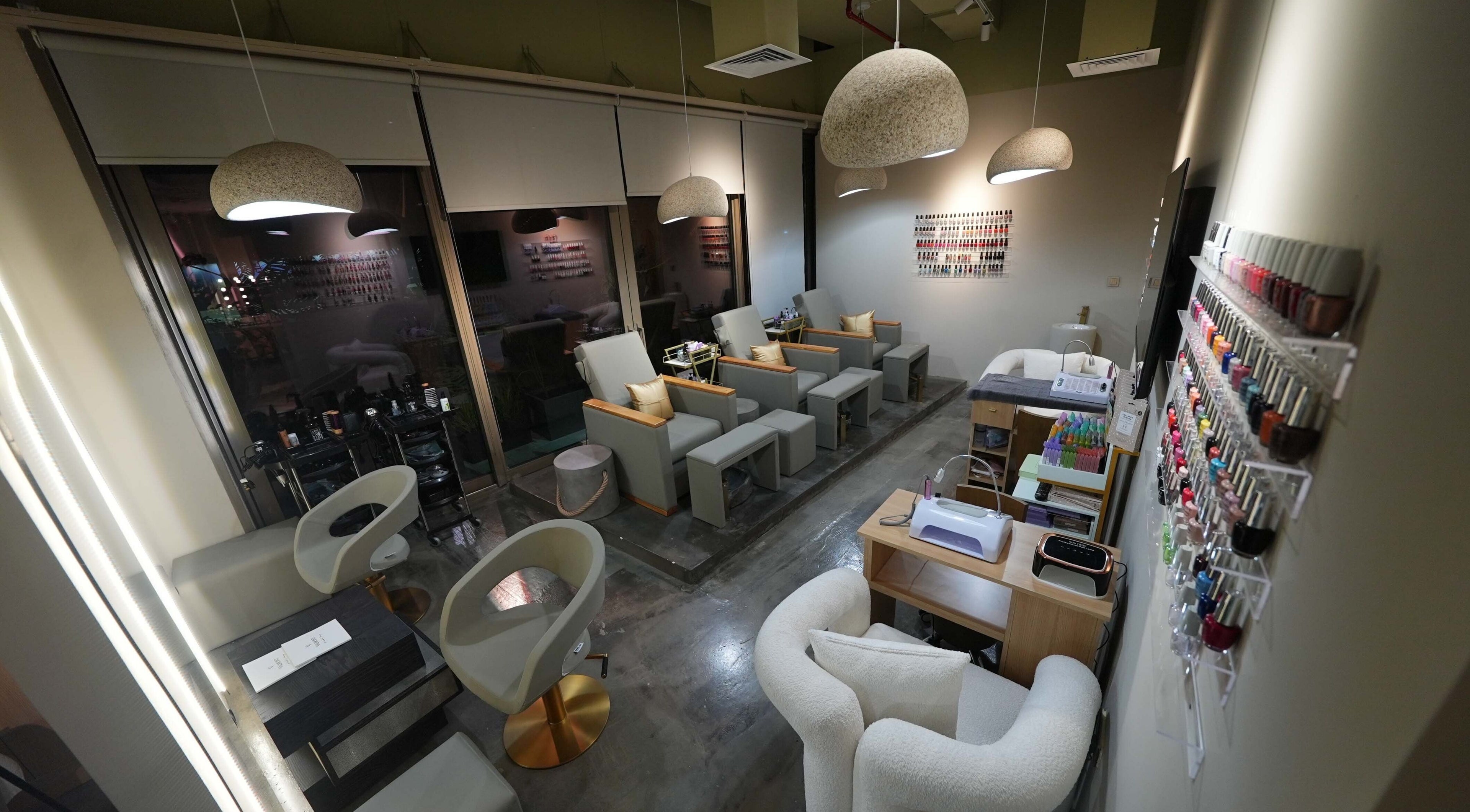 Chic interior of Aceituna Beauty Salon L.L.C in Dubai, Dubai, AE with modern seating and nail polish display.