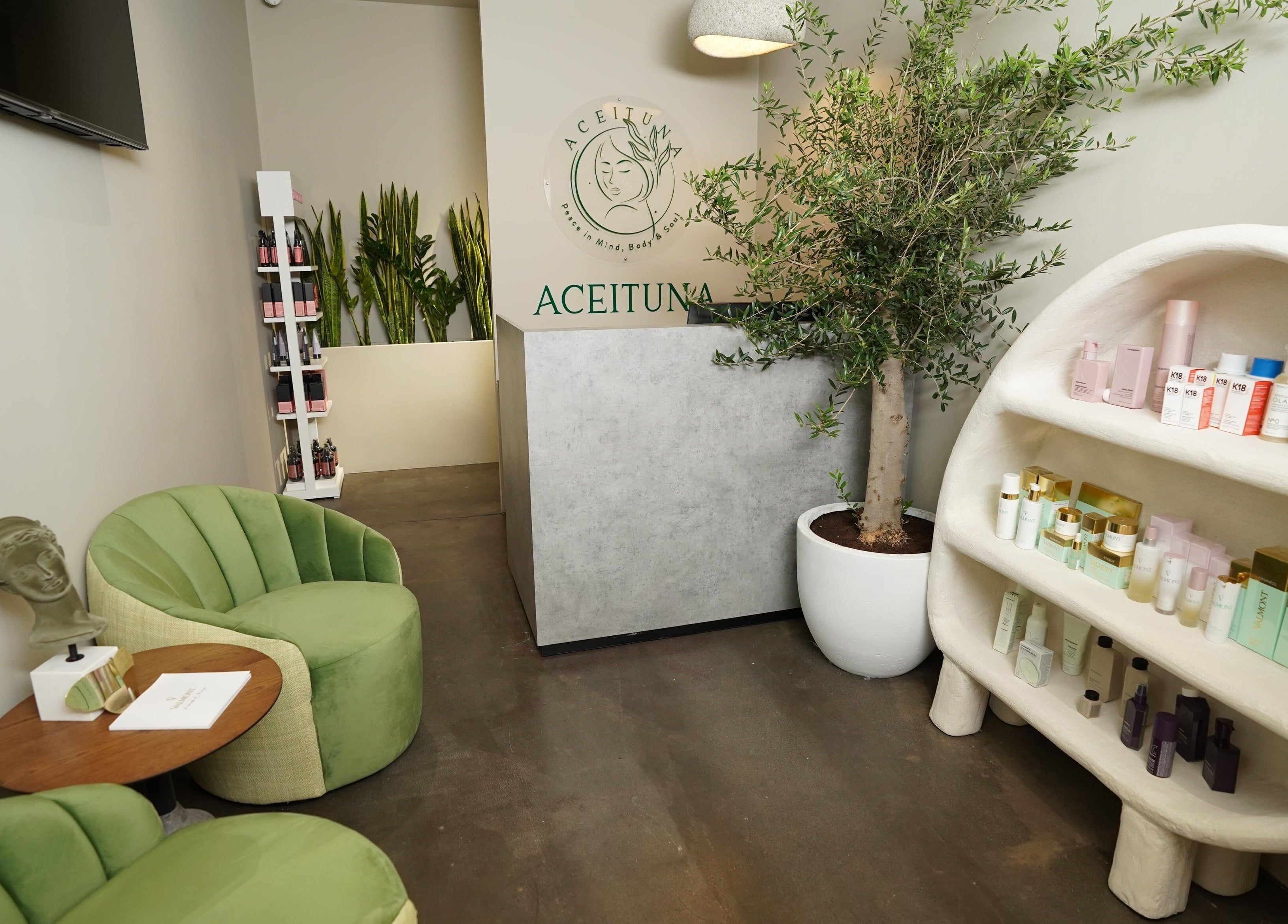 Relaxing interior of Aceituna Beauty Salon L.L.C in Dubai, Dubai, AE with green chairs and elegant product display.