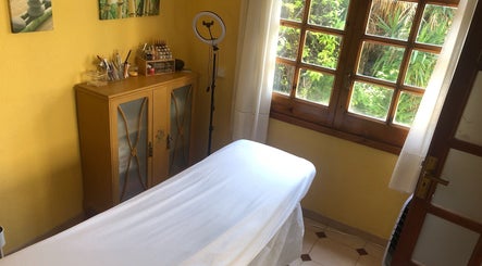 Acogedora sala de terapia en Cris Falcão Beauty PMU, Cambrils, Cataluña, ES, con cama y luz natural.